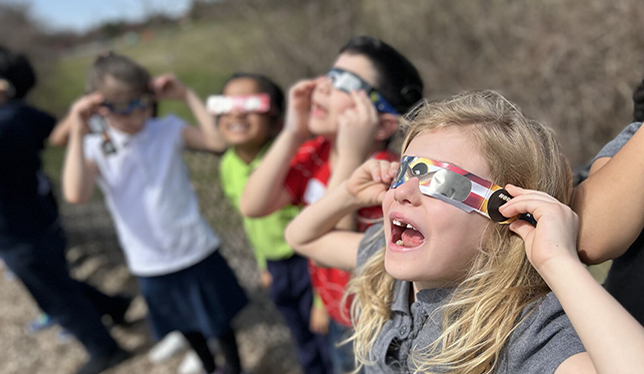 Students using glasses to look at the Solar Eclipse