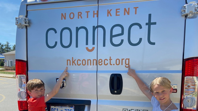 Students pointing at North Kent Connect van