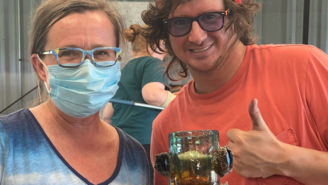Two people at a glass blowing shop.