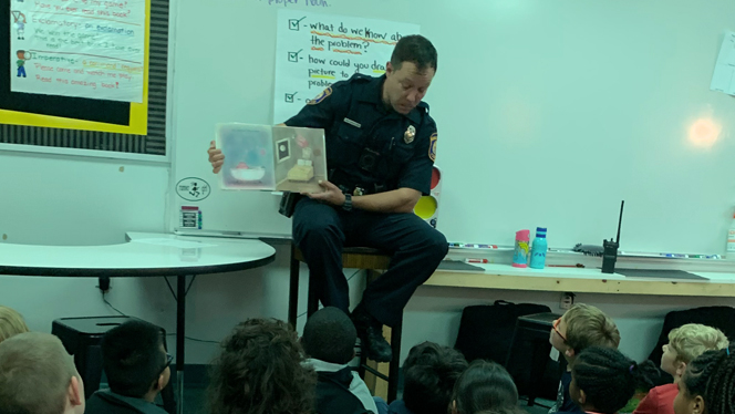 Police officer reading to class.