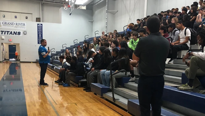 Staff talking to group of students.