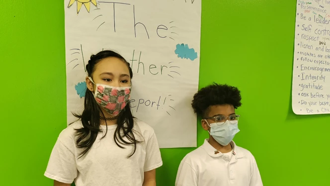 Students standing in front of wall