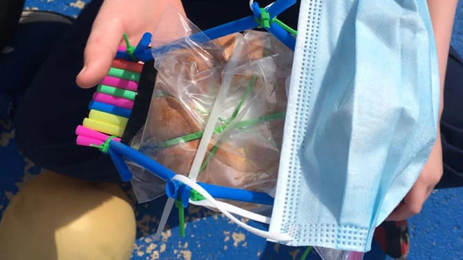 Student showing their egg protecting device. Student showing their egg protecting device.