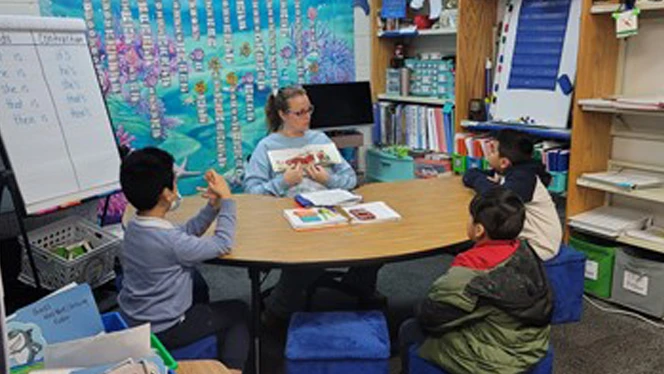 Students learning at a table. Students learning at a table.