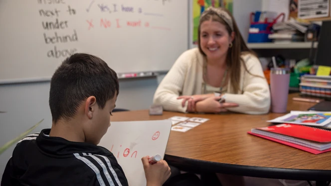 A student writing on a whiteboard. A student writing on a whiteboard.