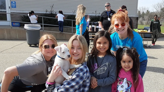 People holding a puppy.