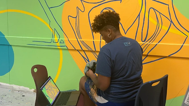 Artist working on mural.