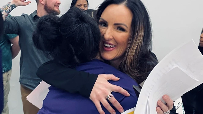 K-8 School in Flint: Sixth grade teacher Renae Voight receives a hug from a student after she was named as the Mid-Michigan NOW Golden Apple Award winner by WEYI-TV in Flint.