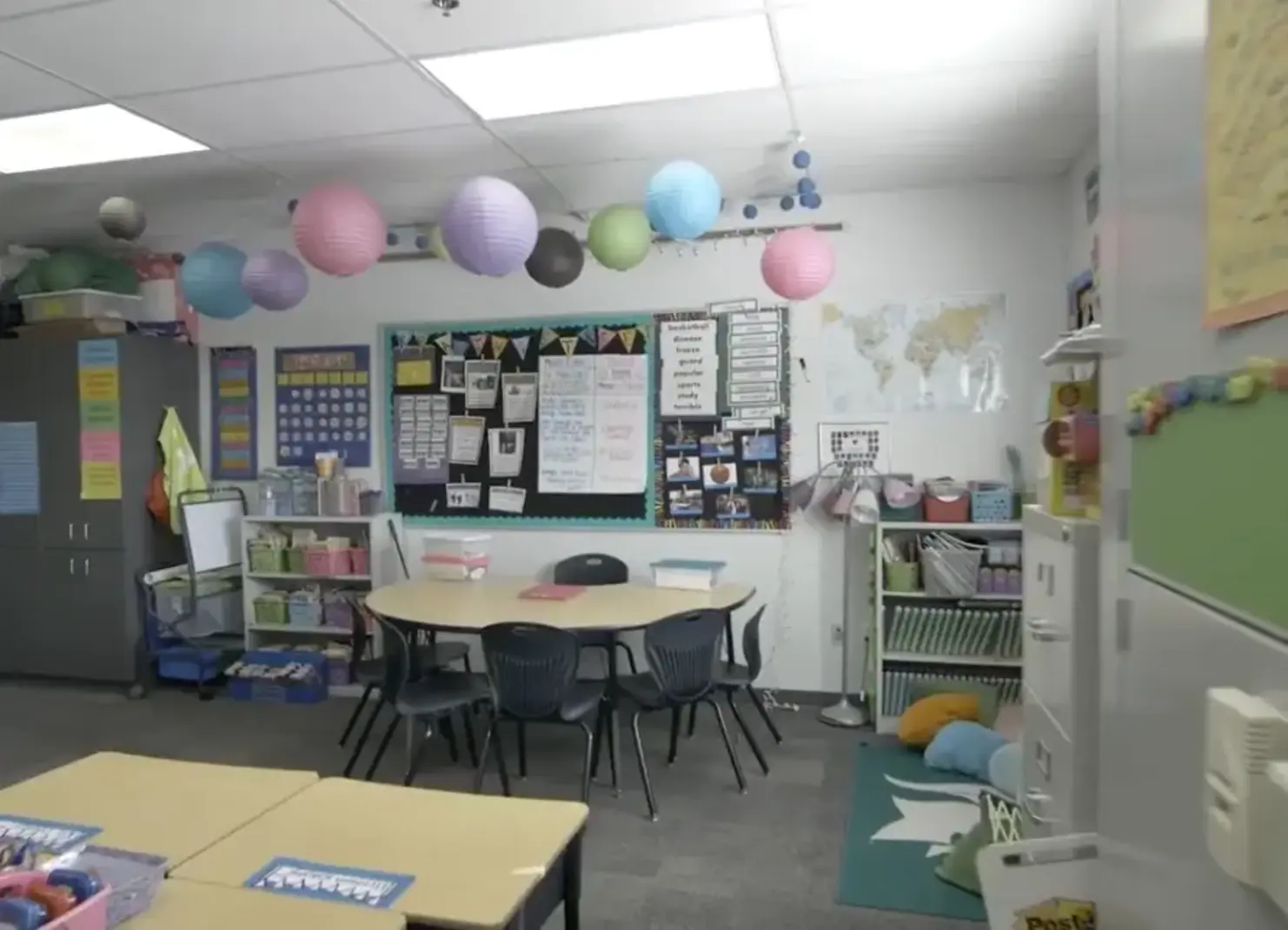 Classroom with desks and bright colored wall hangings.