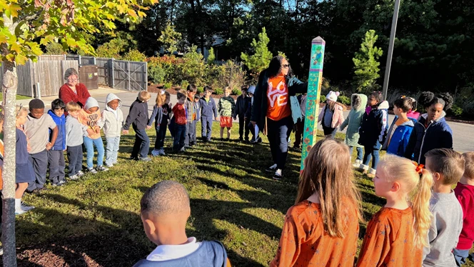 Class standing around the Peace Pole.
