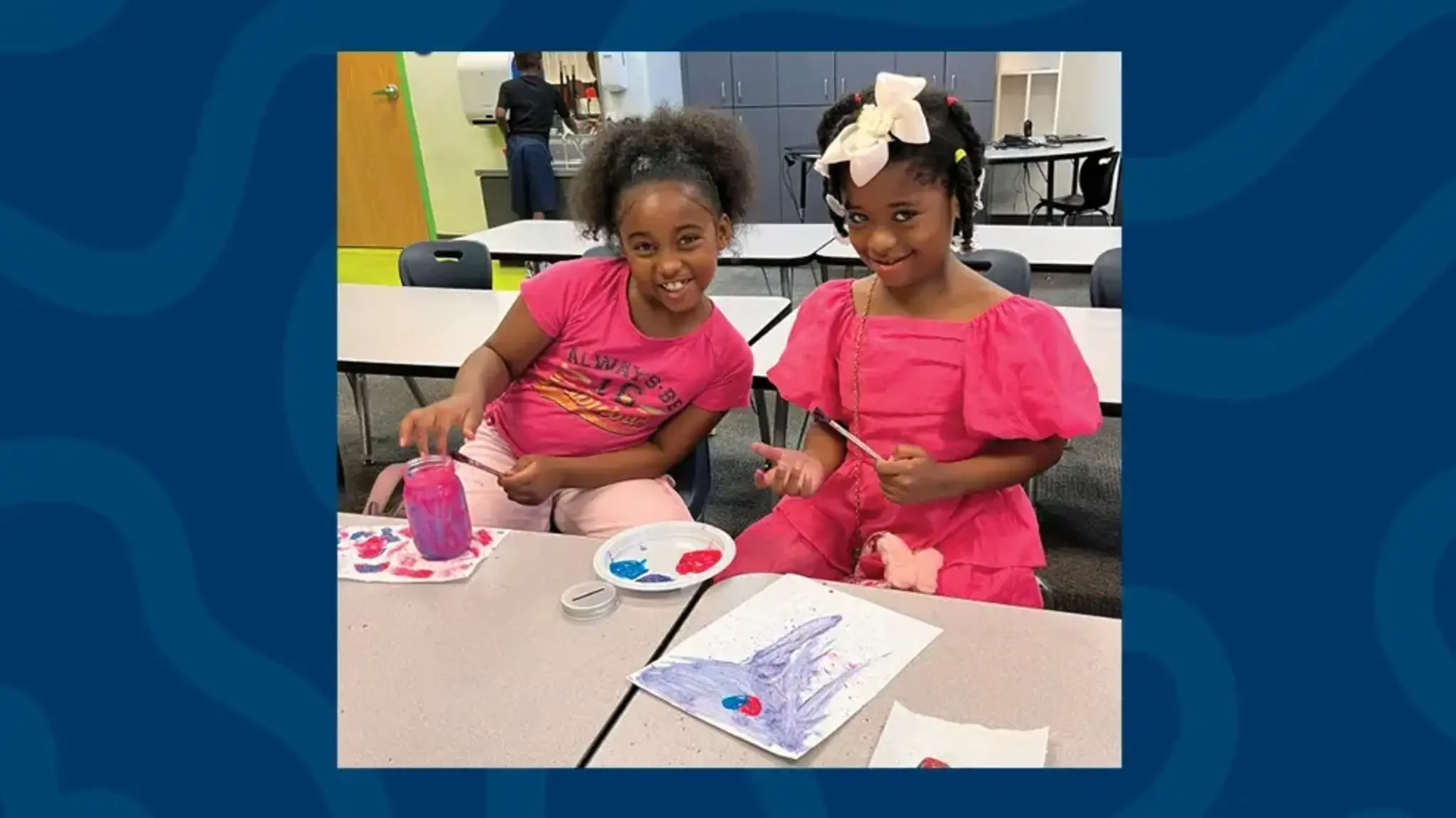 a group of girls sitting at a table painting