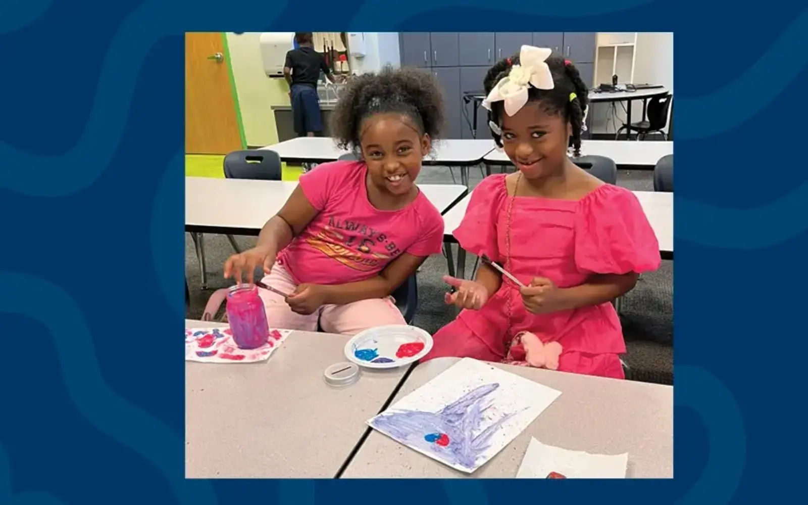 a group of girls sitting at a table painting
