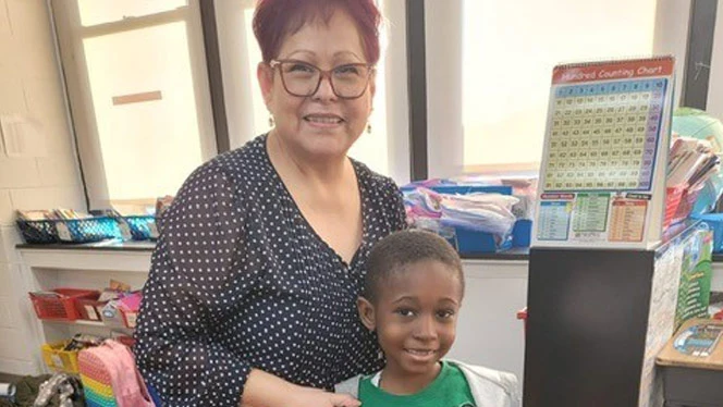 Gonzalez smiling with student.