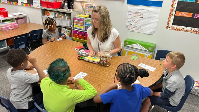 Lindsey Shehu teaching students at a table