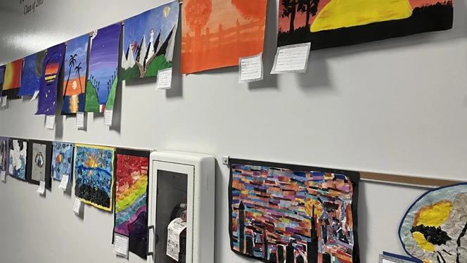 Student paintings lining the wall. Student paintings lining the wall.