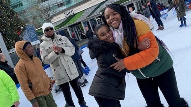 Students ice skating and hugging