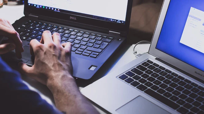 man typing on laptop