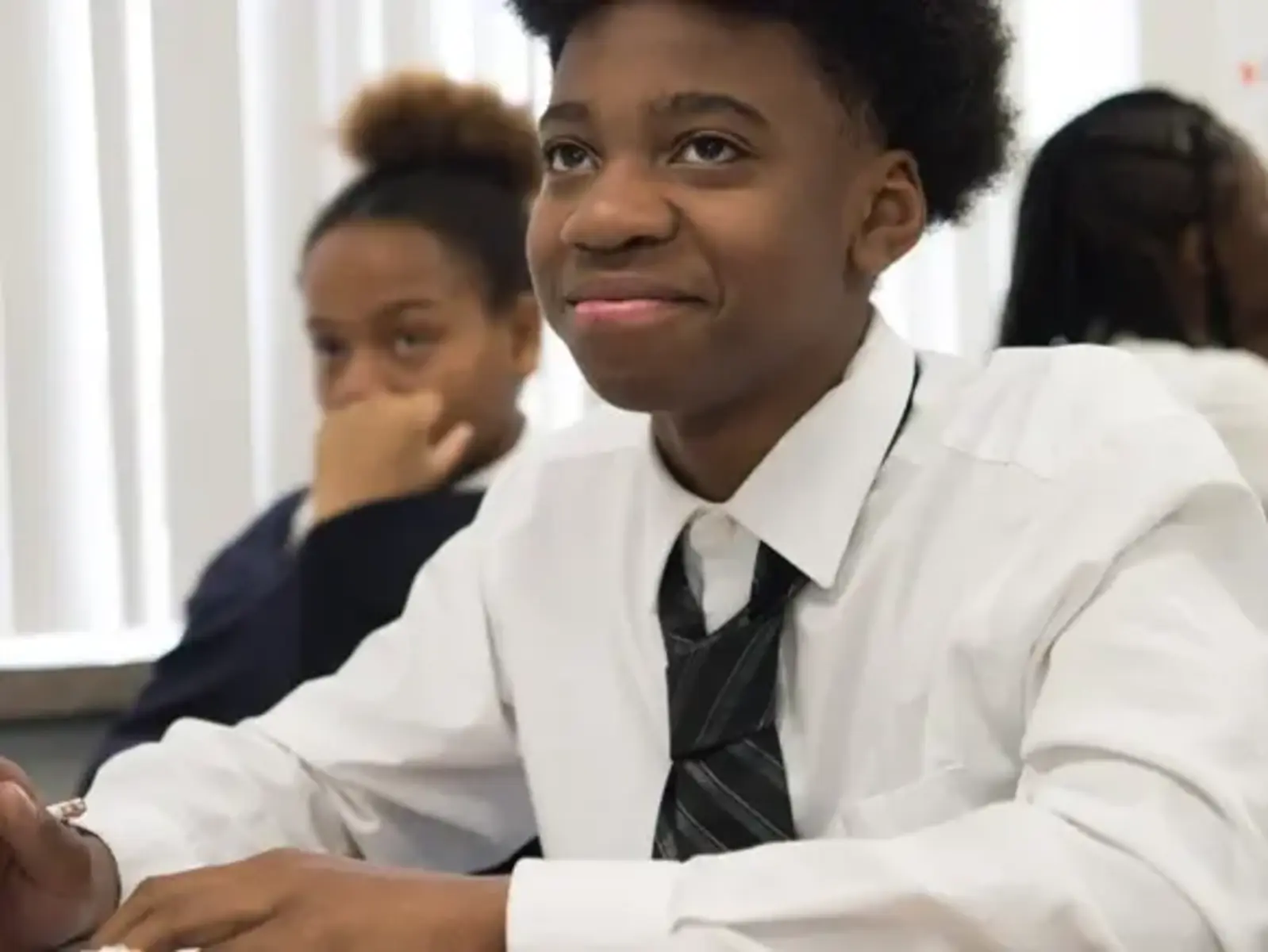 Student sitting in class with white dress shirt and tie