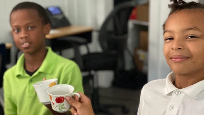 Students clinking tea cups.