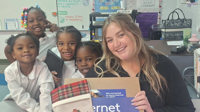 Teacher with students and laptop.