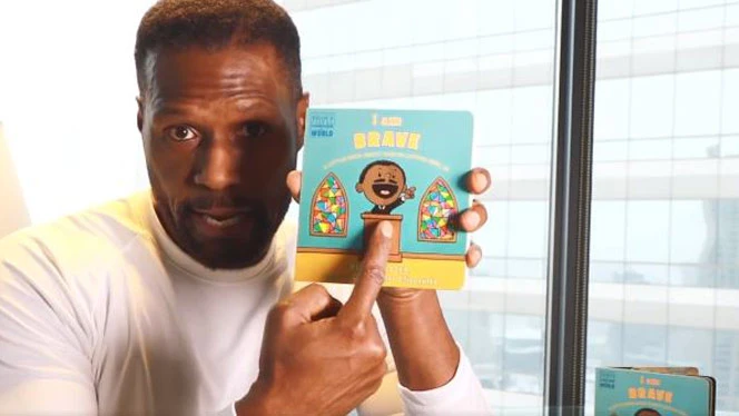 Man pointing to a book called I Am Brave.