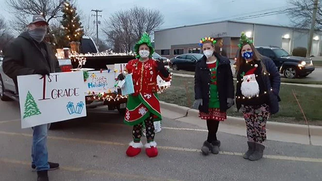Teachers dressed up in front of a truck with Christmas lights on it. Teachers dressed up in front of a truck with Christmas lights on it.