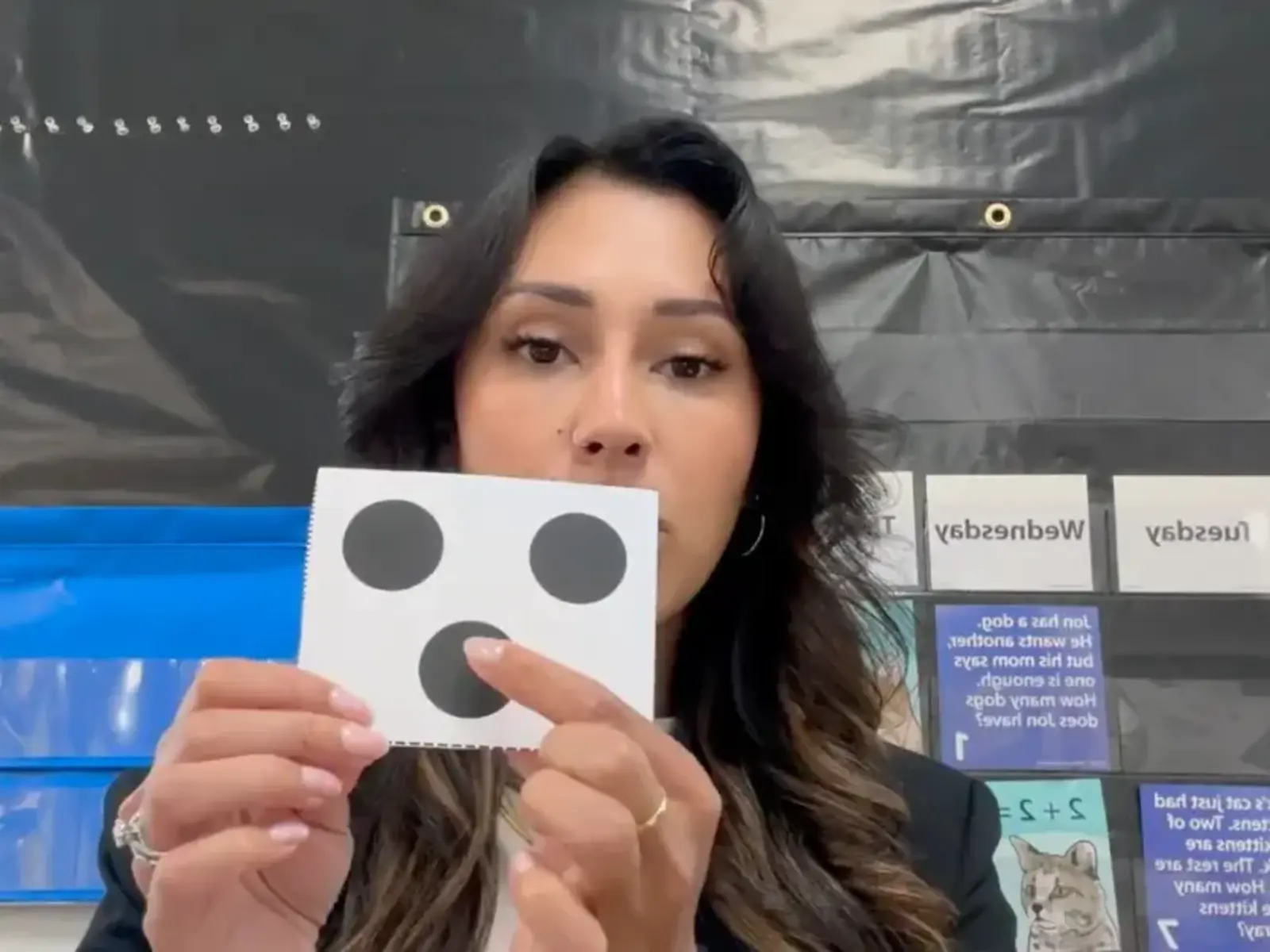Teacher holding up number card and counting to three.