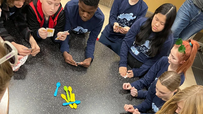 Team playing spoons while waiting for award ceremony