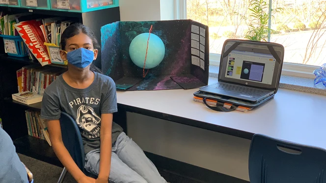 A Peak student displays their solar system unit project