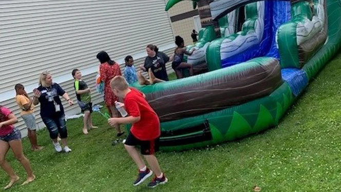 Kids playing on large bounce slide.