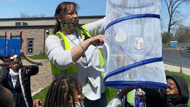 Teacher holding butterfly with students