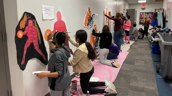 Students painting basketball players. Students painting basketball players.