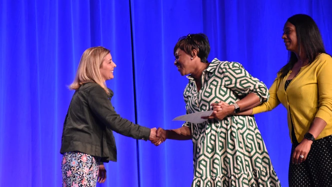 Two women smiling and shaking hands. Two women smiling and shaking hands.