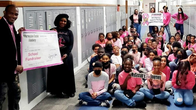 Teachers holding a poster raising awareness about the school fundraiser. Teachers holding a poster raising awareness about the school fundraiser.