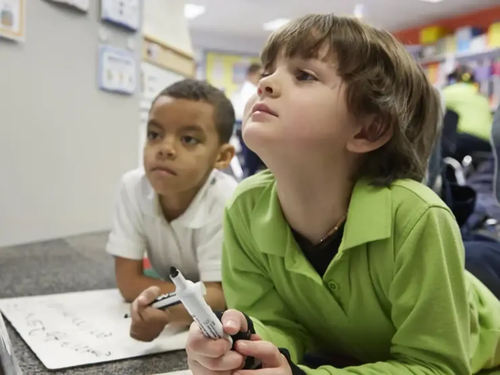 K-12 School in Center Line: Two students using whiteboards to do class work.