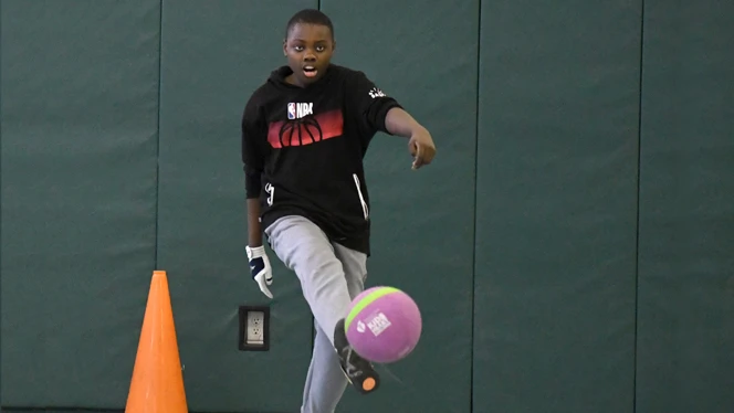 A member of The Amigos team kicking the ball. A member of The Amigos team kicking the ball.