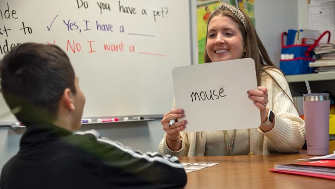 A teacher working with a student on reading. A teacher working with a student on reading.