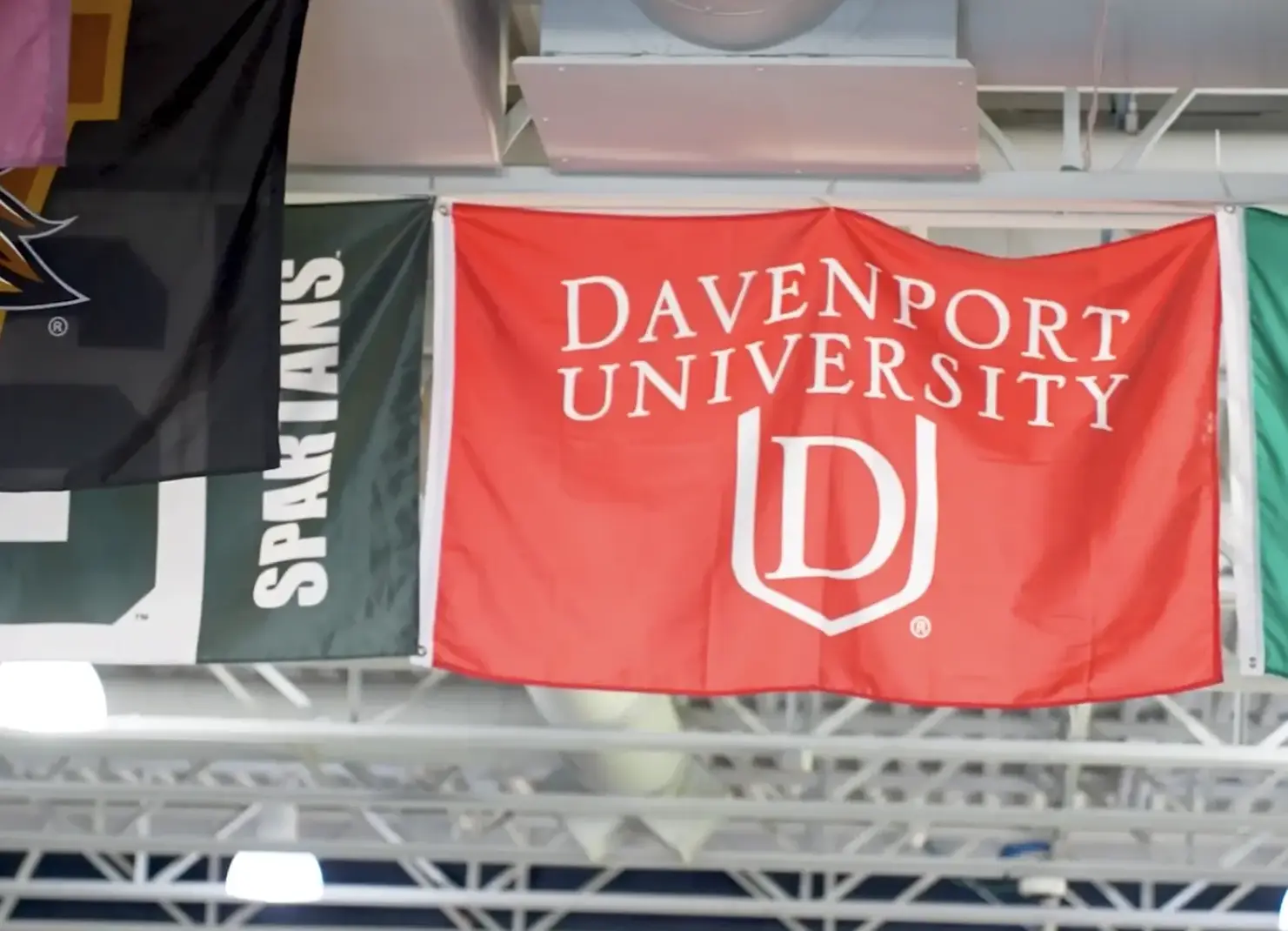 College flags hanging from school rafters.