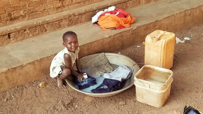 South Sudanese child washing their clothes. South Sudanese child washing their clothes.