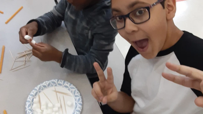 Student posing with marshmallows and toothpicks.
