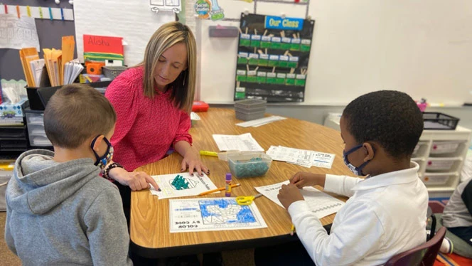 teacher and students at a table teacher and students at a table