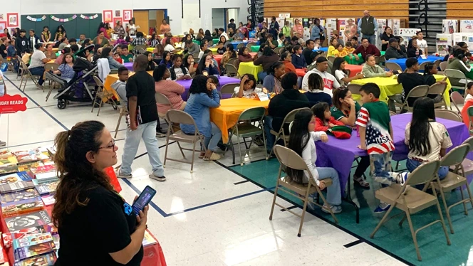 Students and families watch presentation.