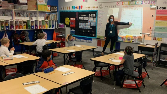 Teacher pointing to her drawings on the whiteboard. Teacher pointing to her drawings on the whiteboard.