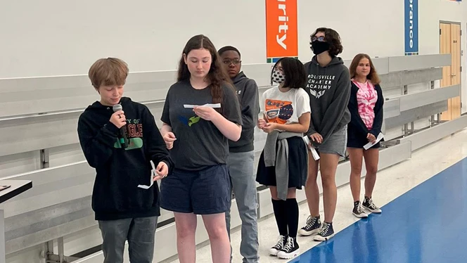 Students reading from slips of paper.