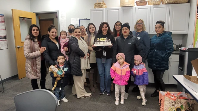Adults holding a cake smiling. Adults holding a cake smiling.
