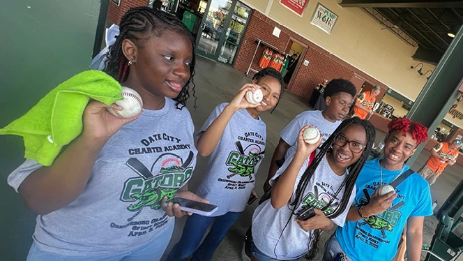 K-8 School in Greensboro: Gate City Charter Academy choir hold baseballs from the Greensboro Grasshoppers minor league baseball game.