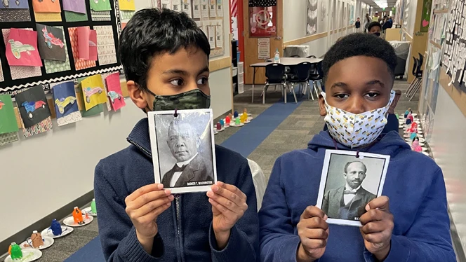 Students holding up more photos of black history figures. Students holding up more photos of black history figures.