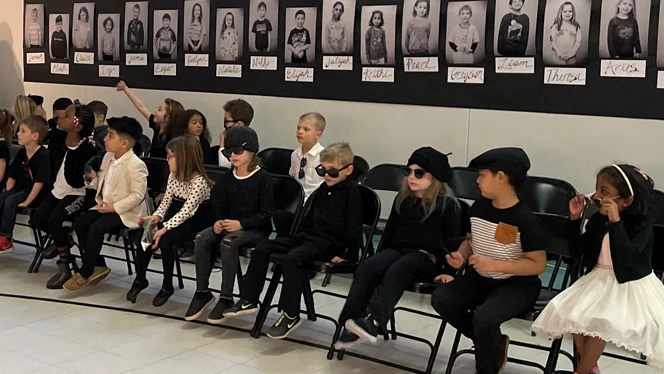 Student with sunglasses sitting in rows of chairs. Student with sunglasses sitting in rows of chairs.