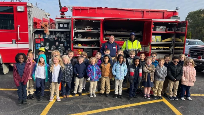 Class standing in front of a fire truck. Class standing in front of a fire truck.