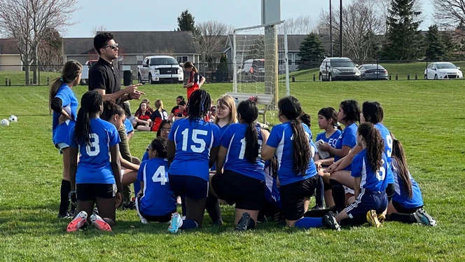 Mr. Hernandez coaching girls soccer team.